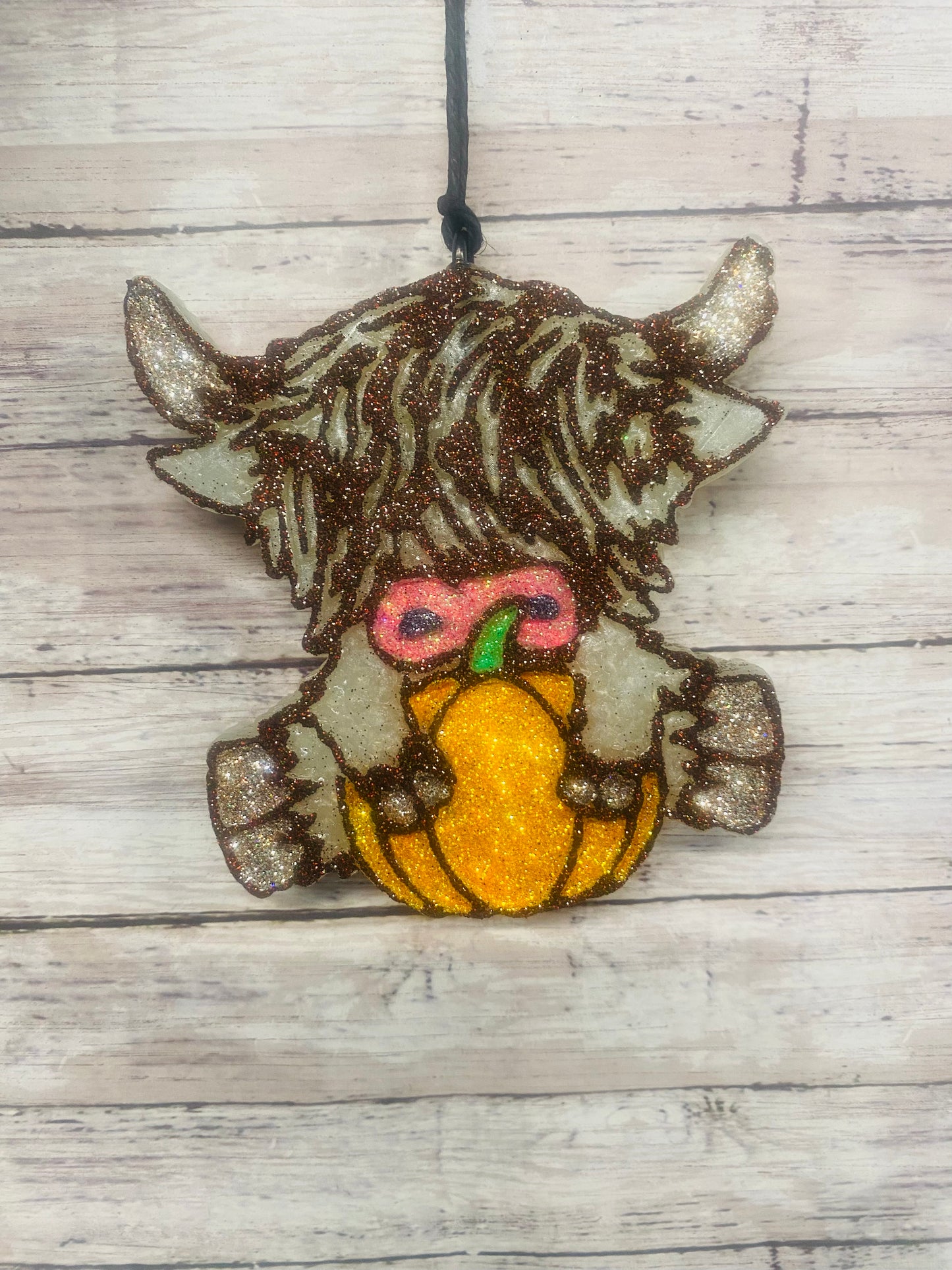 Highland Cow Holding A Pumpkin
